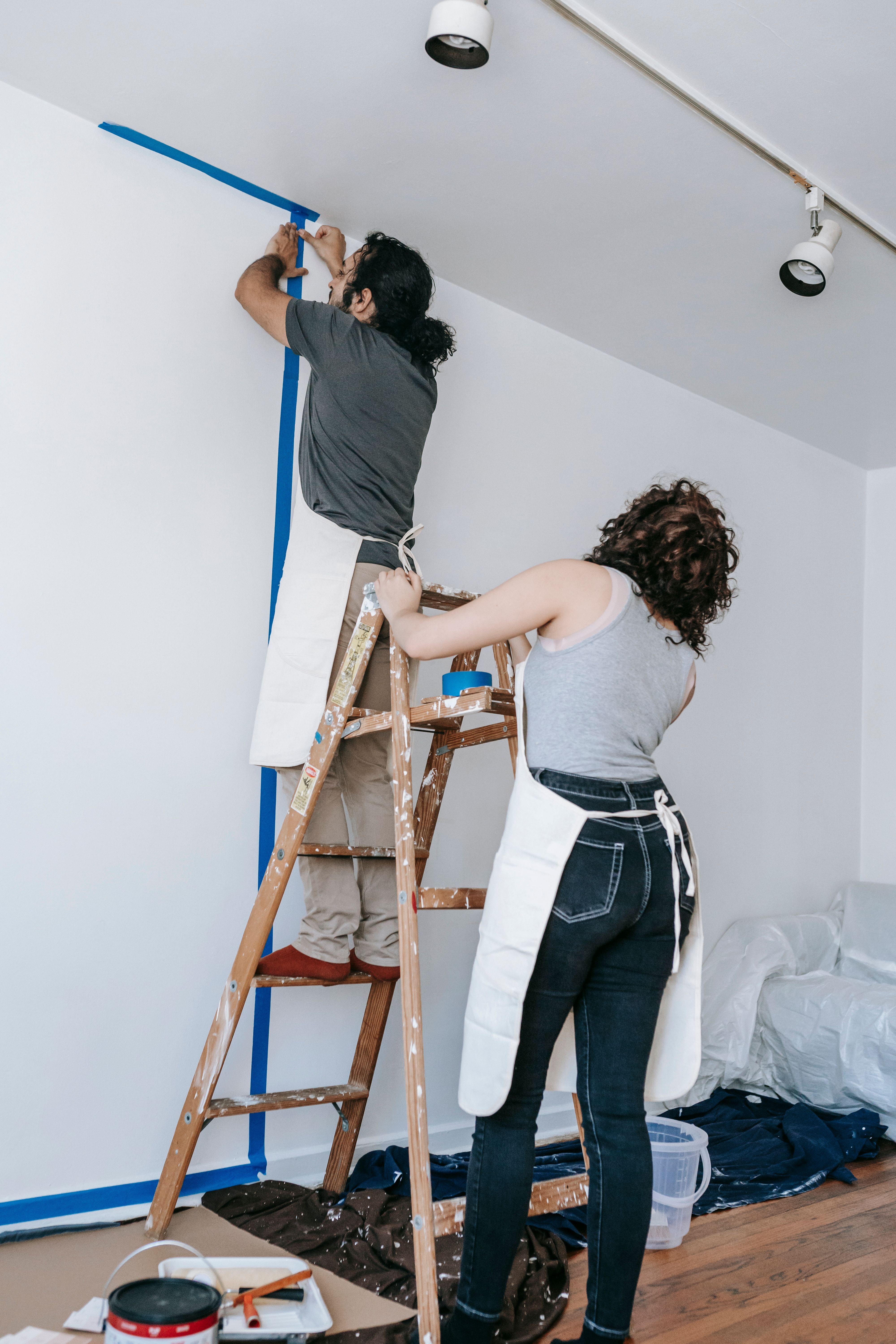 Artisan peintre préparant une pièce en rénovation avant remise en peinture
